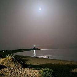 Der Faro leuchtet mit dem Mond um die Wetter