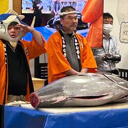 Master chef with assistant wearing goofy tuna fish hat