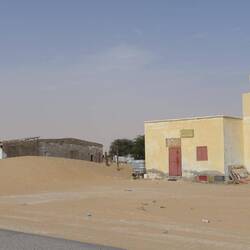 Ein kleines Dorf aus Baracken und kleinen Betonhäusern mit einer Mini-Moschee