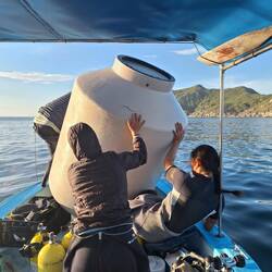 Plastikmüll (der Wassertank eines Hauses) aus dem Meer bergen