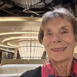 Lee in atrium in front of huge chandelier.