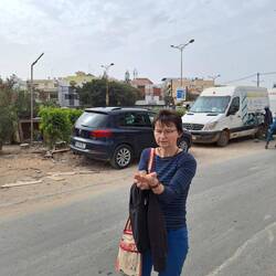 ein Junge mit einem Käfig voller kleiner Vögel; für 15 Cent kann man einen in die Freiheit schicken