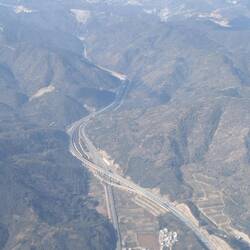 Road and rail infrastructure snaking through the landscape below