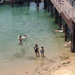 Some holiday makers enjoying the swings under the jetty