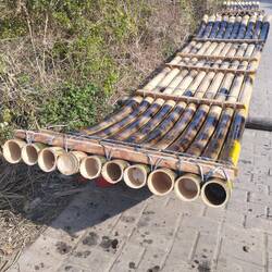 A bamboo raft in the making - heat applied to bend the bamboo pipes hence the blackened areas.