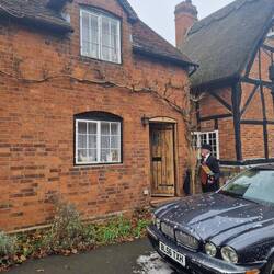 Accordion music outside a home offering mulled wine to the Mummers and audience