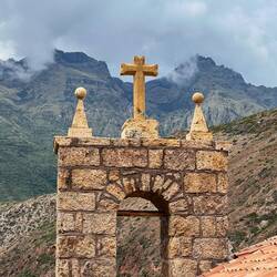 Glockenturm der Kapelle mit Bergmassiv