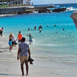 The boys at the water's edge as a plane takes off.