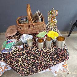 A basket of medicinal items and cups made from old tin cans.