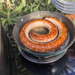 Die Wurst ringelt sich in der Pfanne