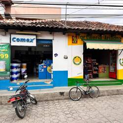 ein Farbladen links, daneben ein Quartierladen mit fast Allem