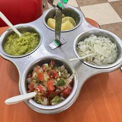 dazu die Beilagen, Zwiebeln, Guacamole, scharfe Essigfrüchte und Zitrone