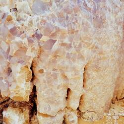 Des milliers de gros cristaux à la forme oblongue et à la couleur laiteuse, parfois rosâtre.