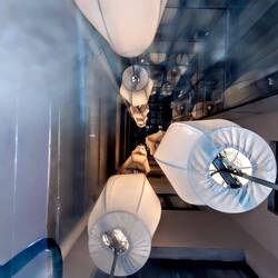 Looking through bars glass floor at lights all the way down the floors