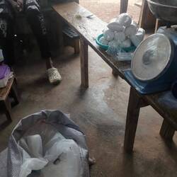 In einem Laden füllen sie Zucker aus einem großen Sack zum Verkauf in kleine Plastiksäcke