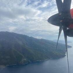 Propeller plane between the leafy hills
