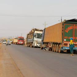 Dieses Dorf scheint wie eine Raststätte für LKWs zu sein - die Frau bietet Getränke an