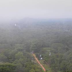 I'm Nebel: Blick auf die "Lustgarten" von oben, hinten eine große Buddha-Statue