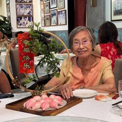 My mother at Spring Court Restaurant with special longevity buns, which are eaten at birthdays.