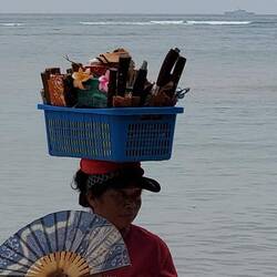 A woman selling her wares on the beach! I bought her blue fan