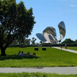Flower sculpture with people having a picnic near by.