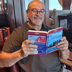 Teammember reading a travel book in the library.