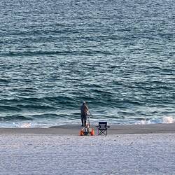 Lone fisherman down on the beach.