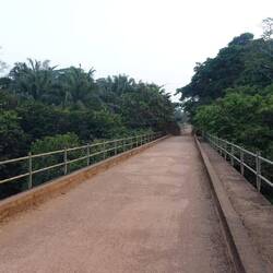 Eine alte Eisenbahnbrücke führt über ihn