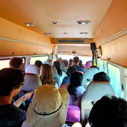 21 Leute im Bus. 2 sitzen auf Plastikstühlen.