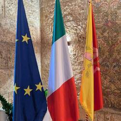 The EU flag, the Italian flag, and the Sicilian flag