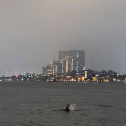 Ein Fischer im Wasser, der nachts ein Netz auswirft