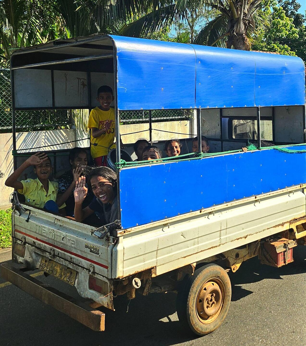 Kids on their way somewhere, drumming and singing