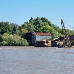 A retired boat in the Tigre River. The still active boat on the left is a restored water bus.