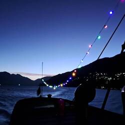 Approaching Queenstown and the evening lights on our boat.