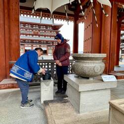 Kind temple attendant showing Kevin how to light the incense - keep incense bundle intact.