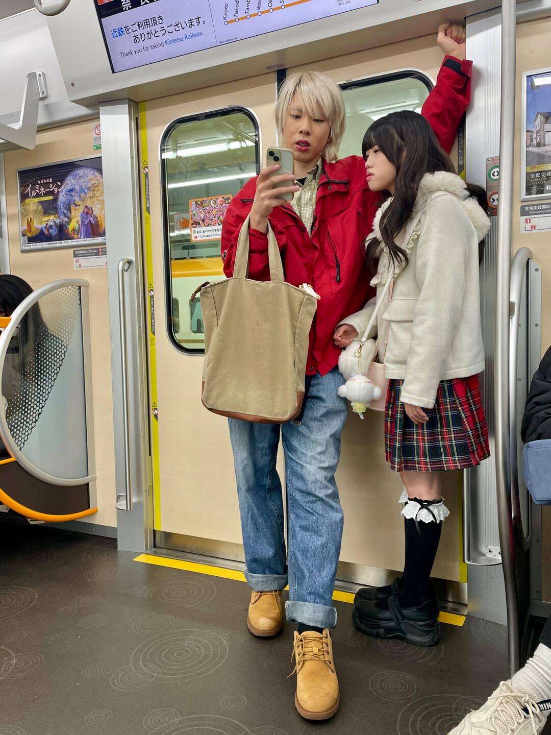 A couple on the train. He had more makeup on than I ever have but she seems to think he's perfect.