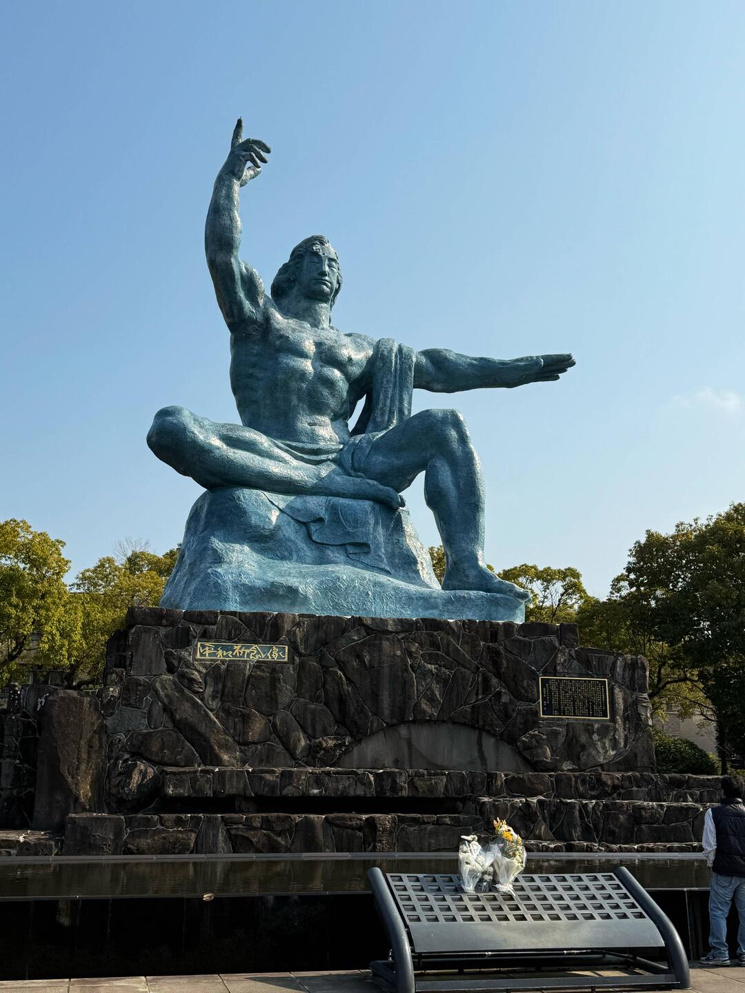 The right hand points to the danger of nuclear weapons, the left symbolizes eternal peace