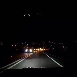 Nachts in Luanda, die Fußgänger (in der Mitte) sind kaum zu sehen