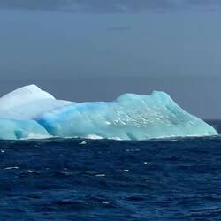 It's more apparent in the video that this berg has rolled over and is showing its underbelly.