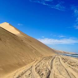 Wie ein Sandwich fahren wir zwischen den über 200 Meter hohen Sanddünen und den Wellen des Atlantik