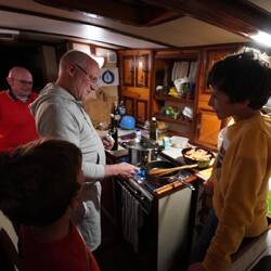 On accueille nos amis à La Canée. Christian explique aux enfants la recette des gambas flambées