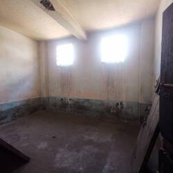 Eine Gefängnisszelle für sechs angekettete Sträflinge