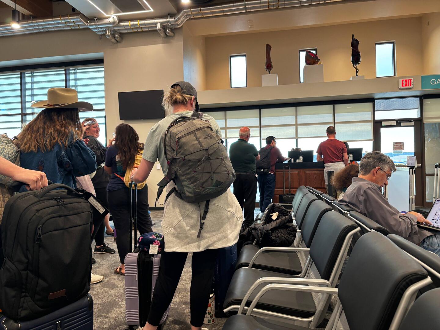Half the passengers are in line to talk with the people weho don't knoow when we can fly.