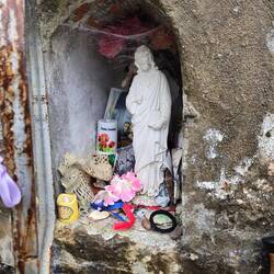 Jesus, Mary is behind him, all the offerings and lit candle