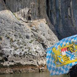 Die Statue mit den Felsen; die Bayernflagge ist nur in das Bild hineingeweht