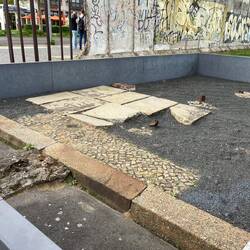 Excavated edge of an intersecting road and pavement which disappeared under the border zone