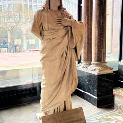 Damaged statue of Jesus with the line from the Lord's Prayer, "forgive us our sins ..."