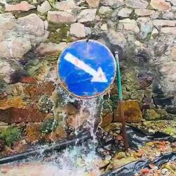 Someone bent the sign to keep the water from spraying onto the road