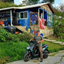 With a rented moped, in front of Sandra's dive shop.