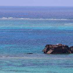 The remains of a ship trapped in the coral reef.